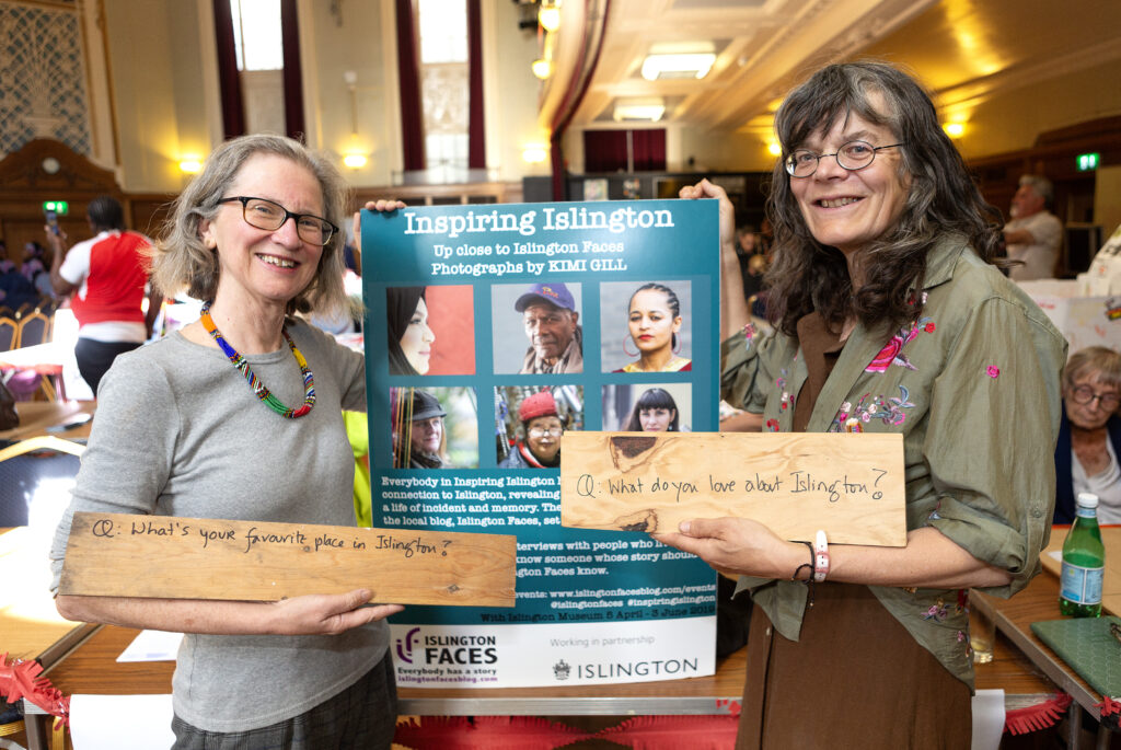Two women holding the Inspiring Islington sign