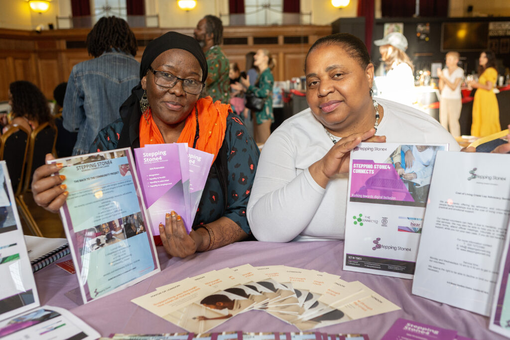 Two women sitting at a table with brochures